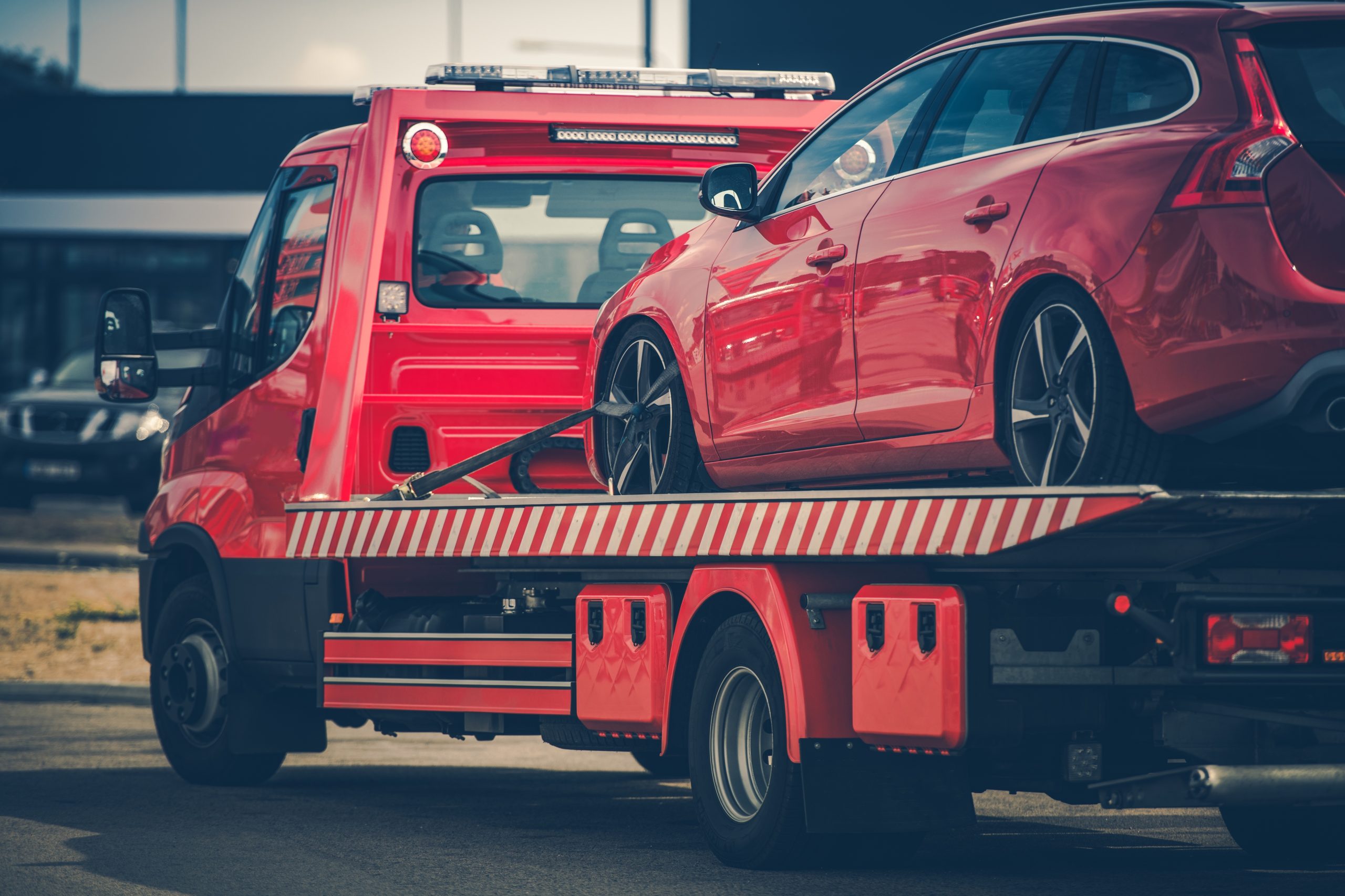 Carro vermelho a ser rebocado após uma avaria